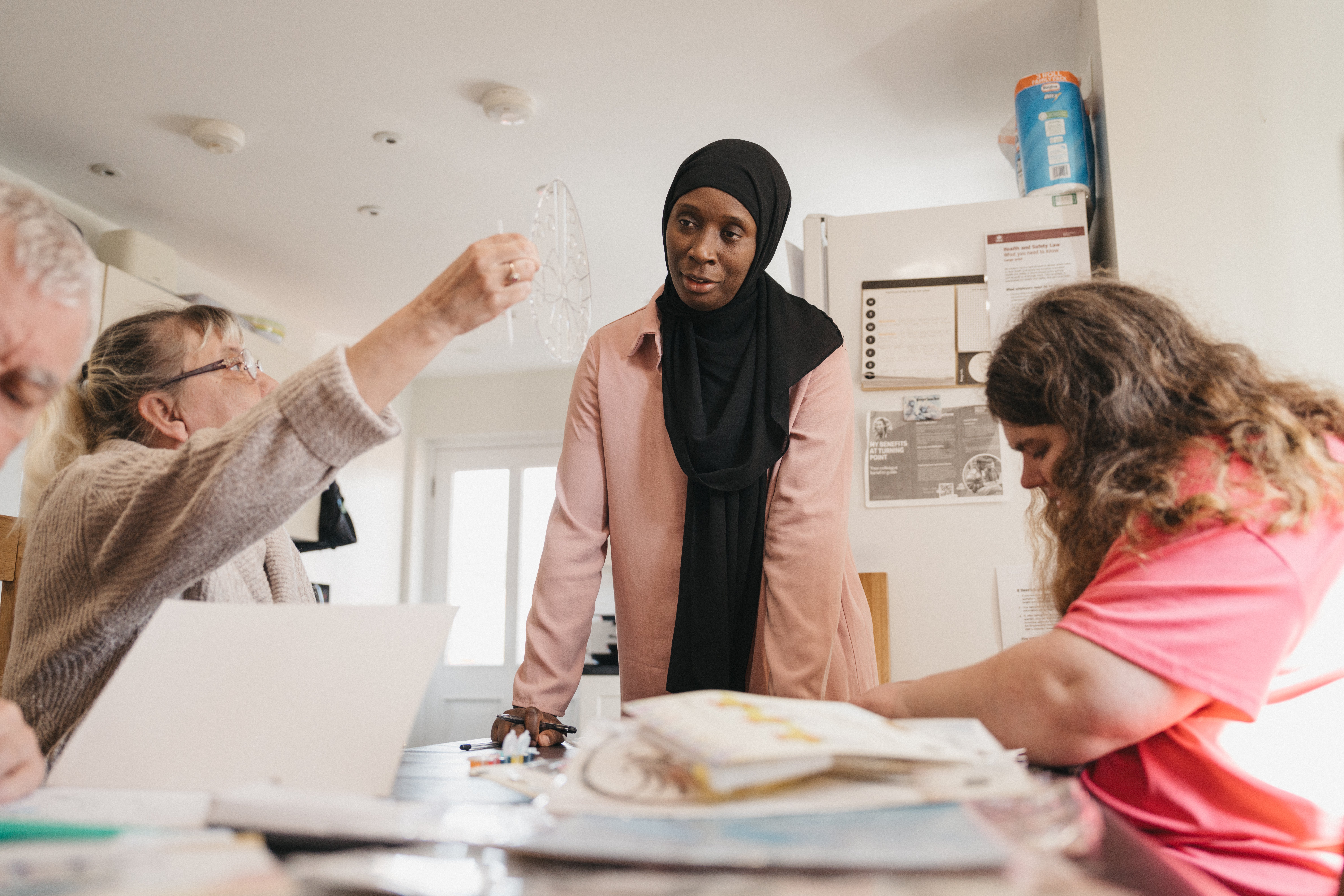 lady wearing a head scarf standing at a table 