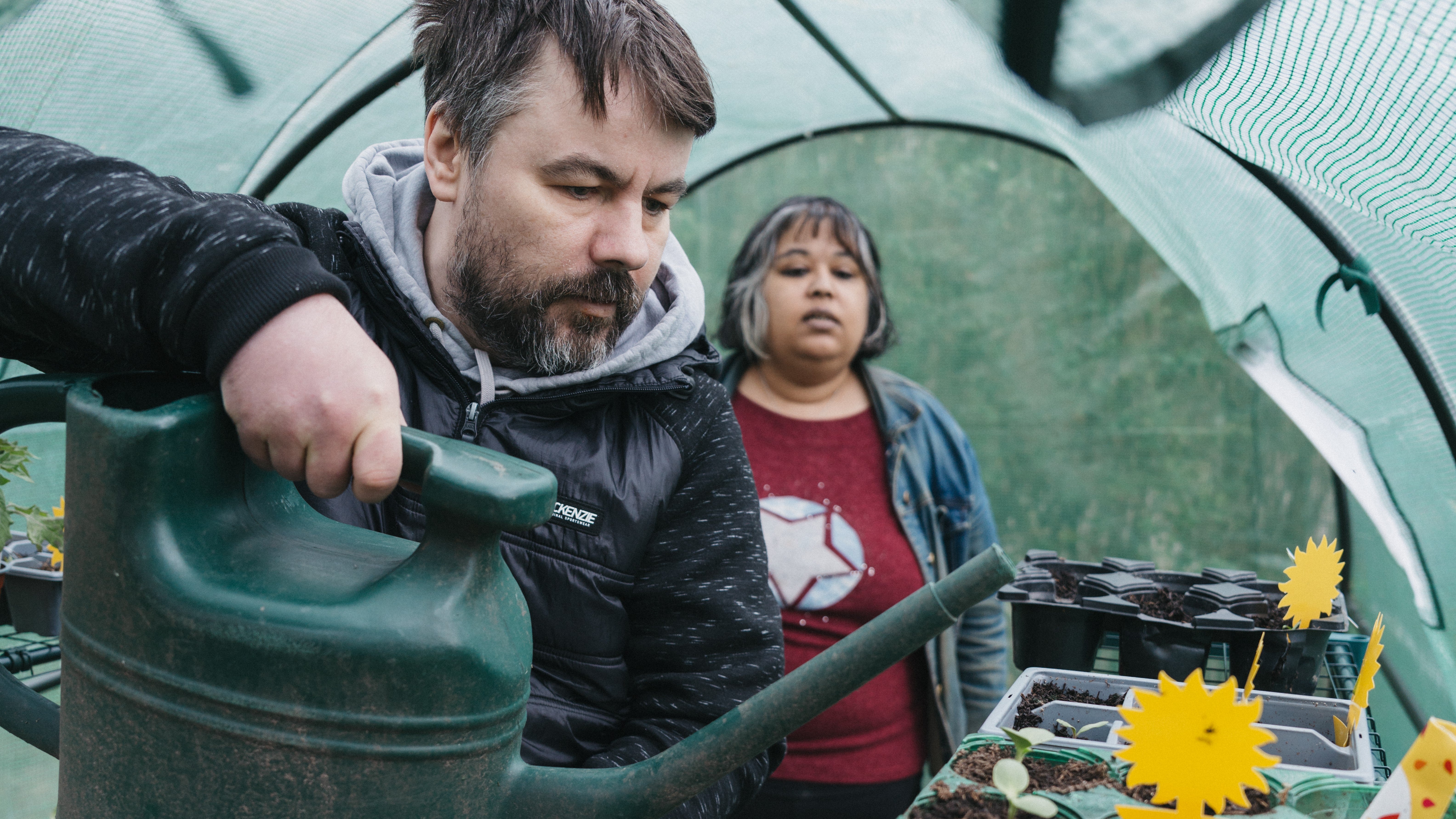 A man and woman watering plants