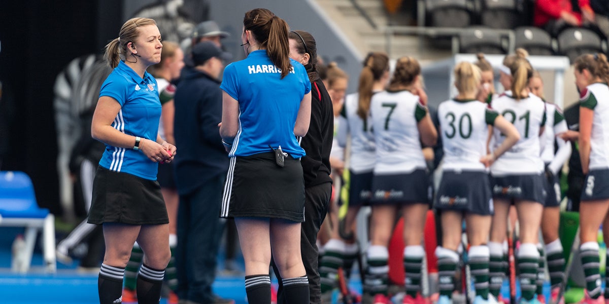 Hockey Umpires having a discussion with a coach