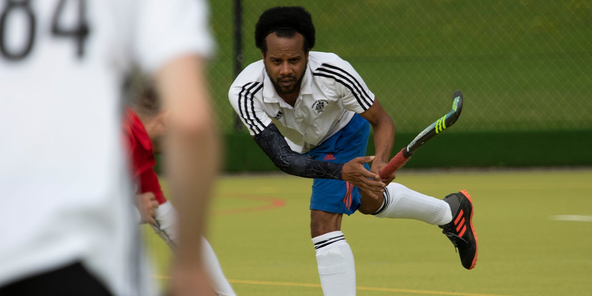 Male from Newbury and Thatcham Hockey Club playing hockey on a green pitch 