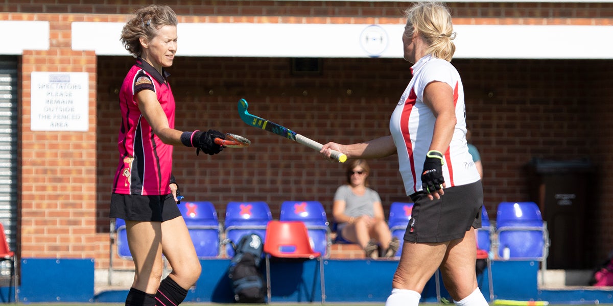 Adult Female hockey players tapping sticks during COVID-19 at England Hockey Championships 2019-20