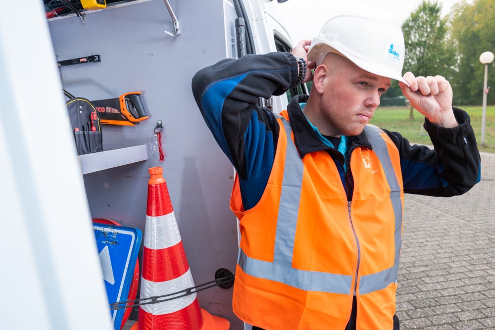 Monteur zet helm op.