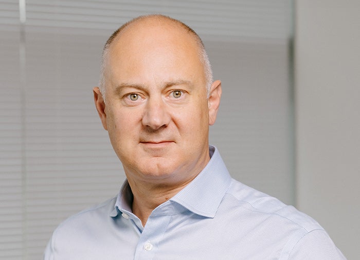 Head and shoulder profile image of a smartly dressed man wearing a light blue shirt