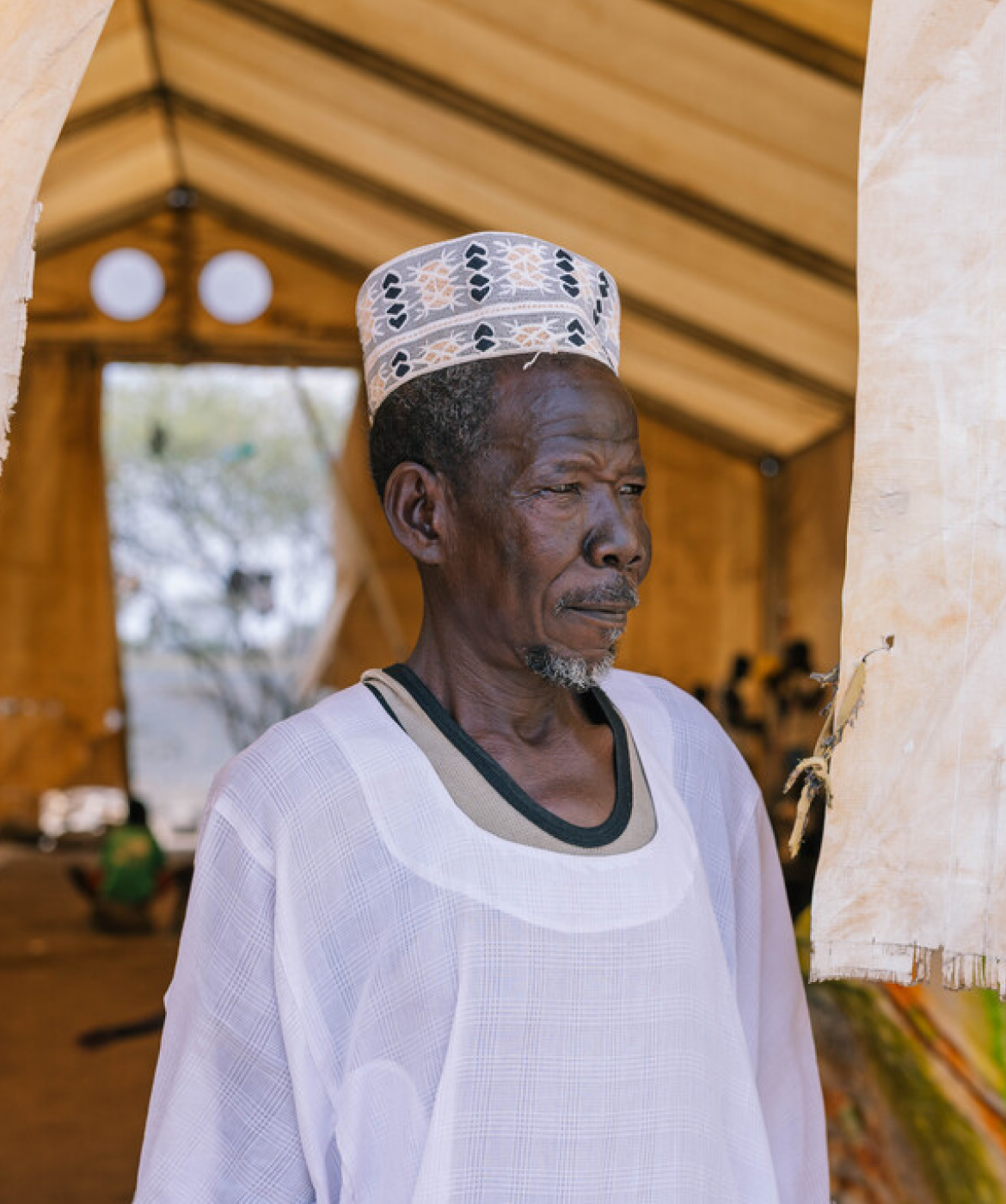 A portrait of Hassan, 62, inside a reception centre in a refugee settlement for people displaced from Sudan.
