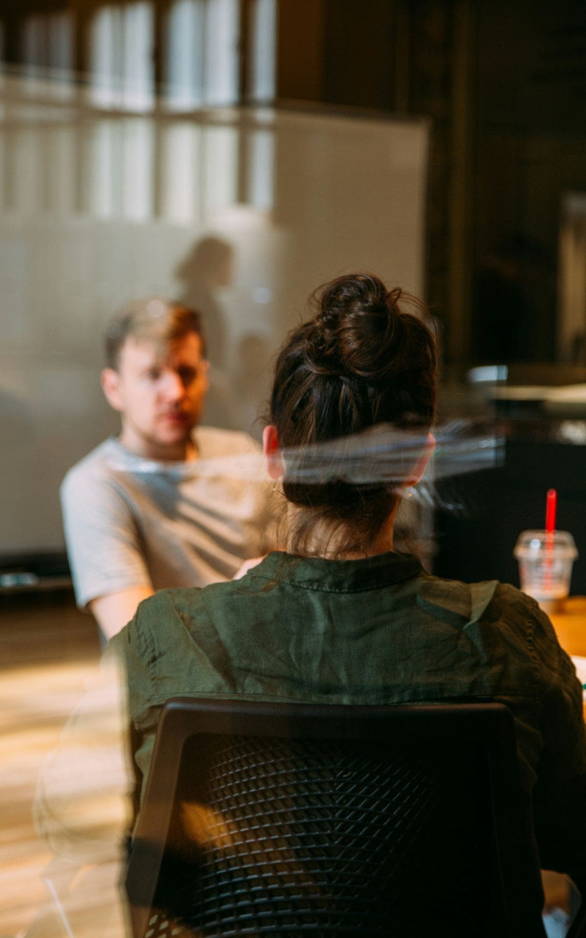 Deux personnes en rendez-vous, vues à travers une vitre