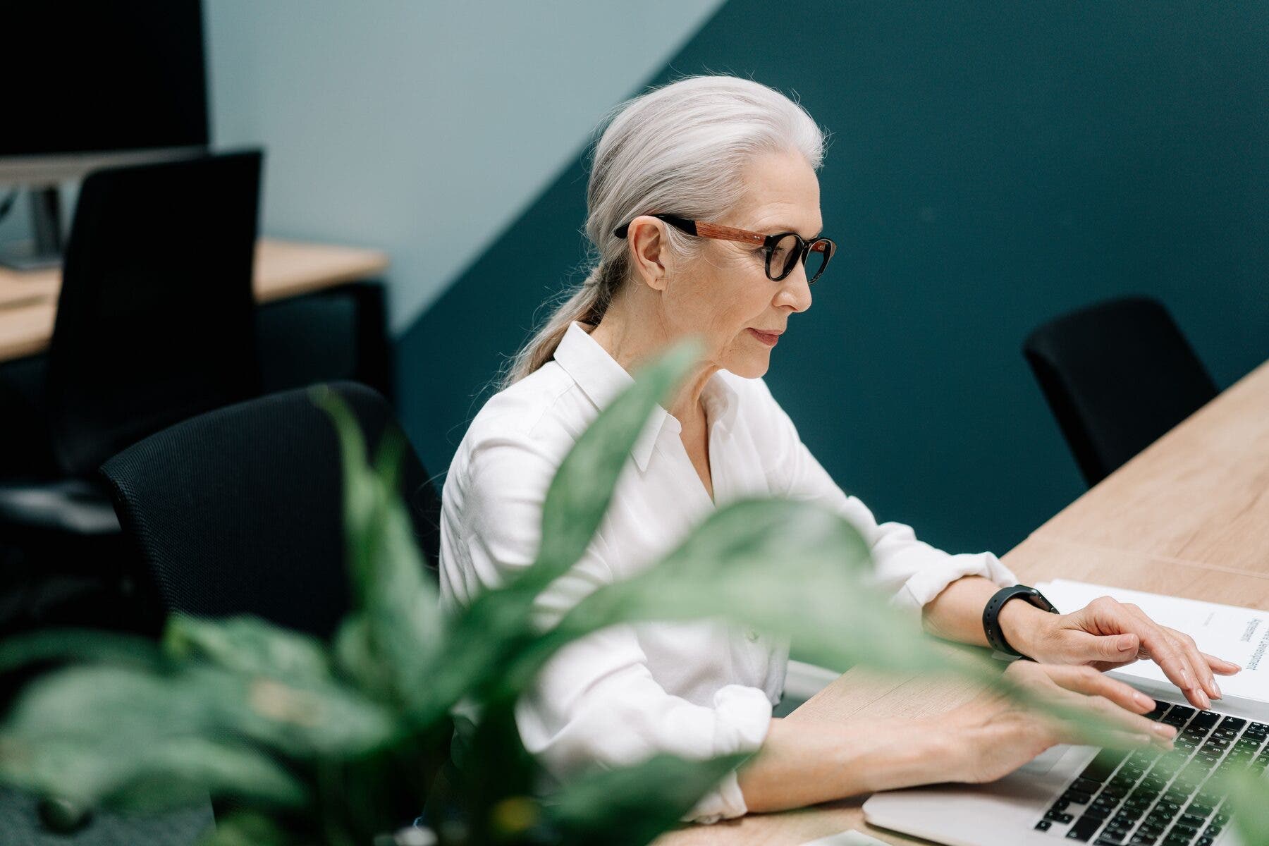 Femme à son bureau devant un ordinateur portable