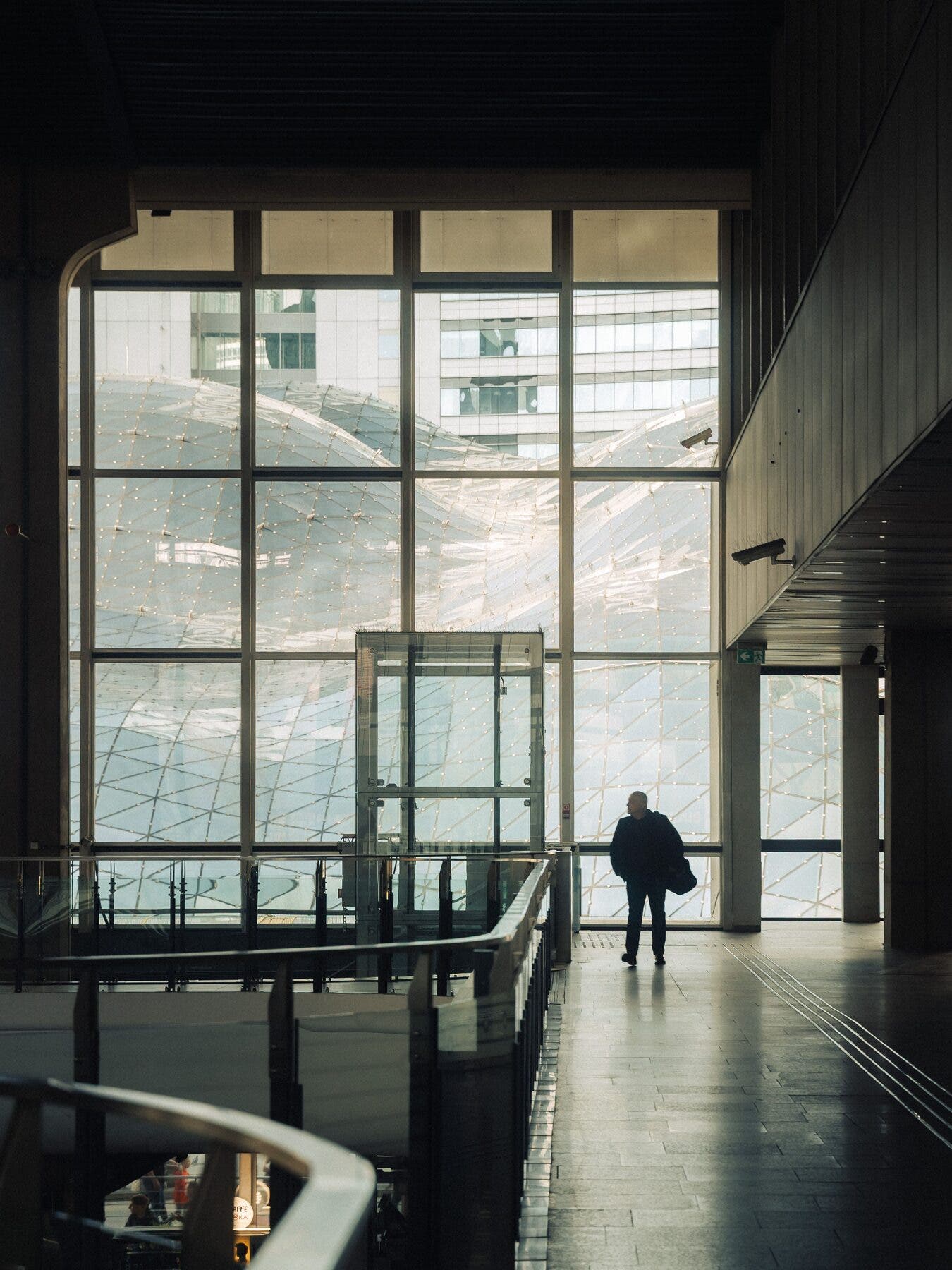 Silhouette sur une passerelle, bâtiment contemporain