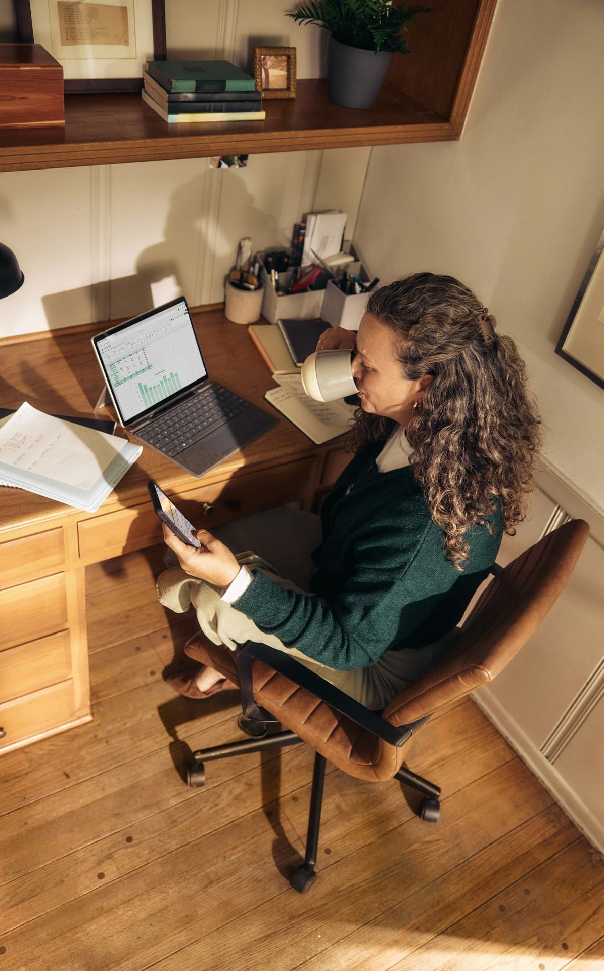 Femme consultant son téléphone à son bureau