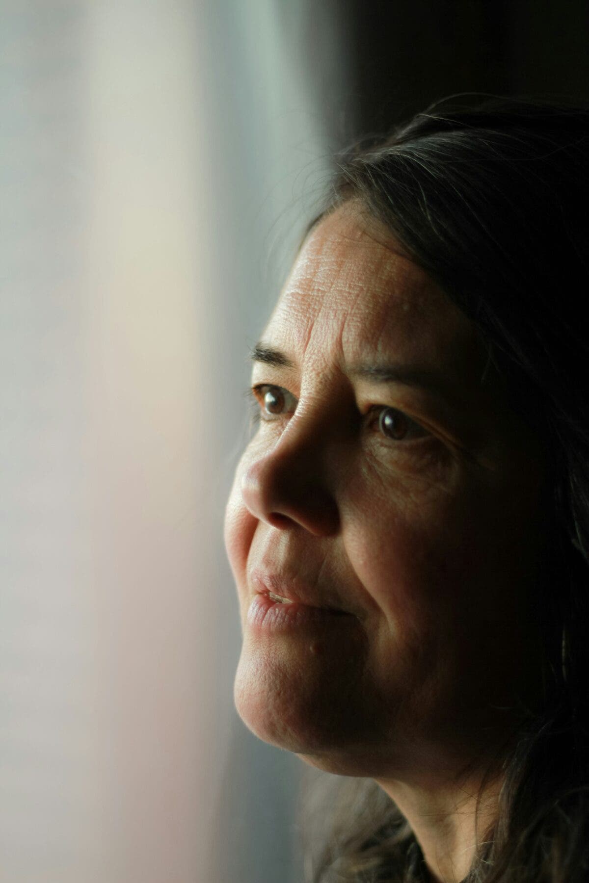 Femme proche de la retraite, regard vers la fenêtre