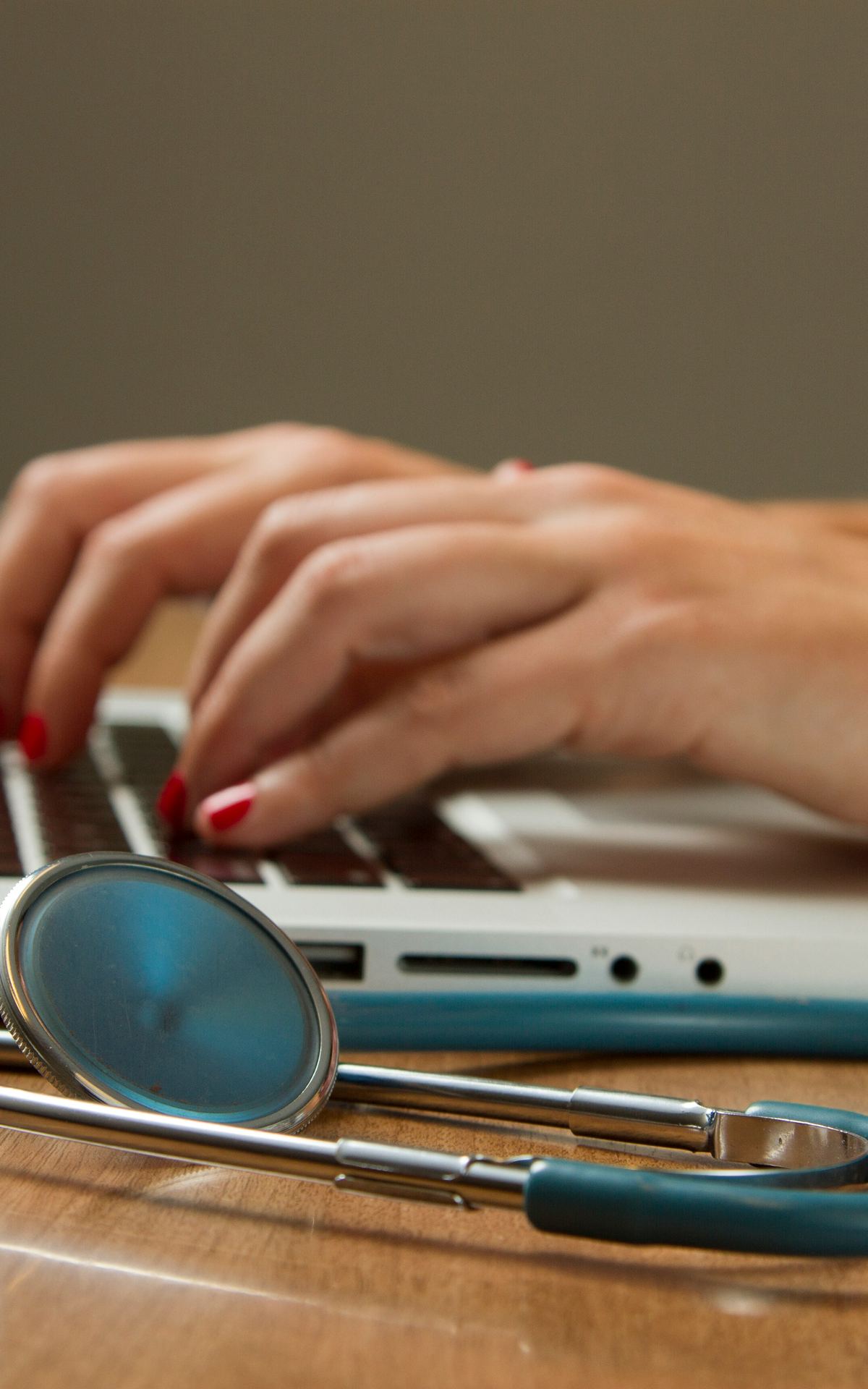 Mains sur un clavier à côté d’un stéthoscope