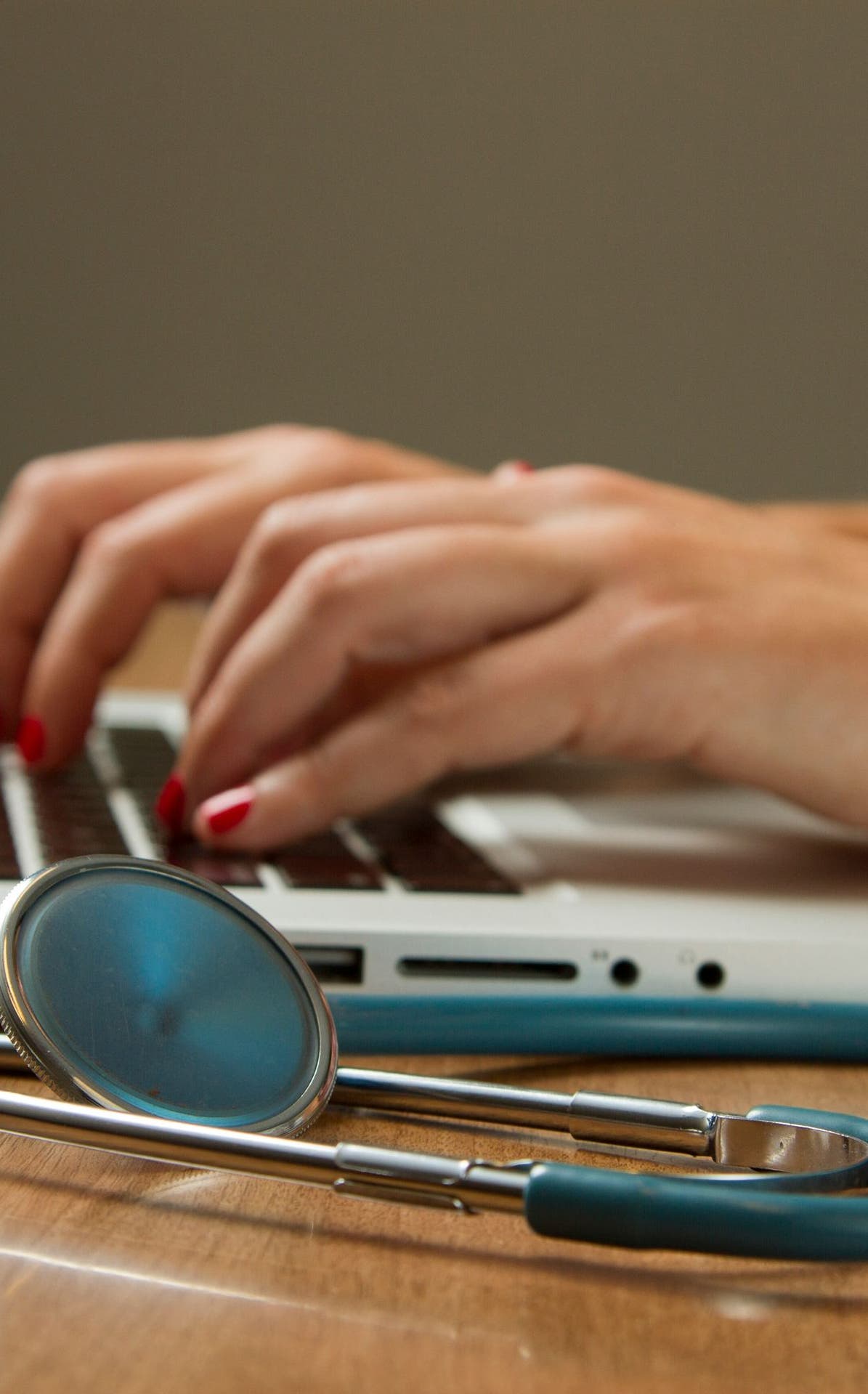 Mains sur un clavier à côté d’un stéthoscope