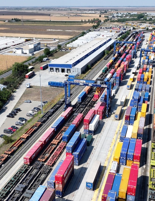 Aerial view of a busy freight train station with colorful containers.