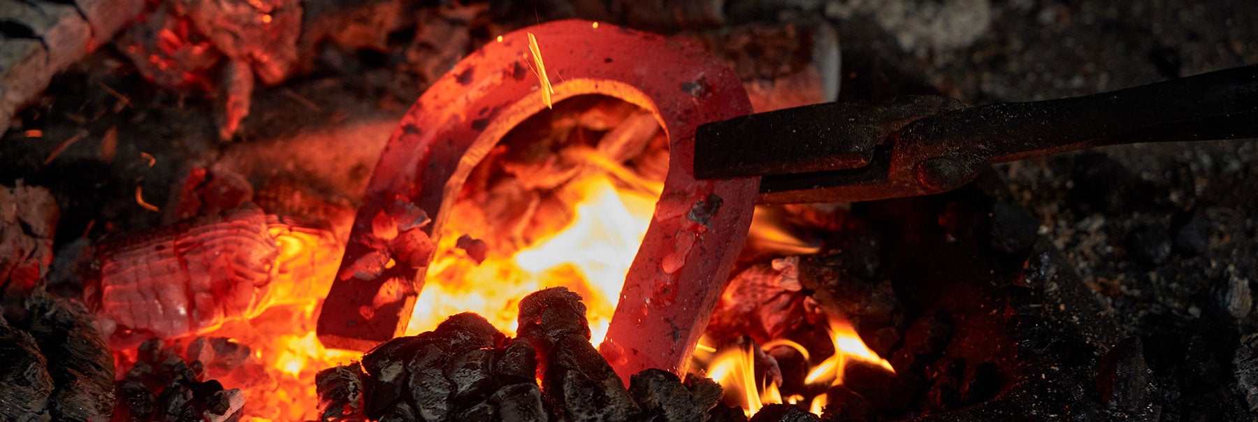 glühendes Eisen in der Esse Hufeisen