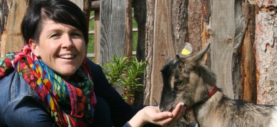 Frau mit Ziege beim füttern