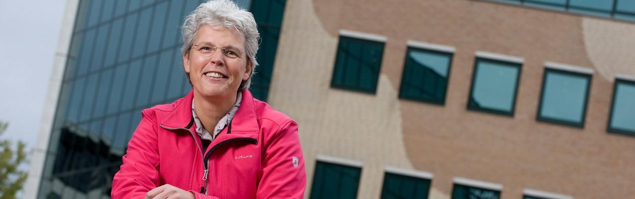 Docente Marinda van Harskamp staand voor het hoofdkantoor van Markus Verbeek Praehep in Hilversum.