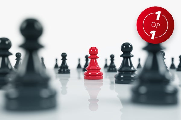 Zwart-witfoto van schaakbord met zwarte pionnen, in het midden één felrode pion. Tekst in rode cirkel: 1 op 1