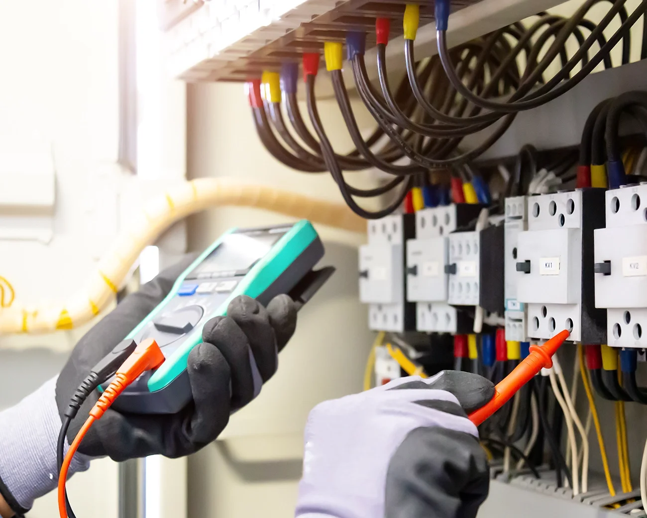 Elektricien die metingen verricht aan een elektrisch paneel