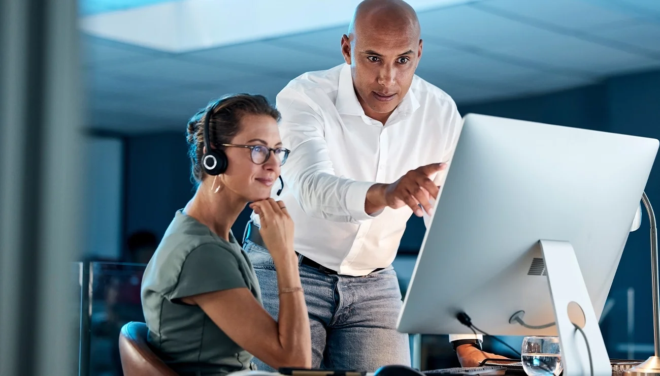 Twee mensen die samen naar een computer kijken
