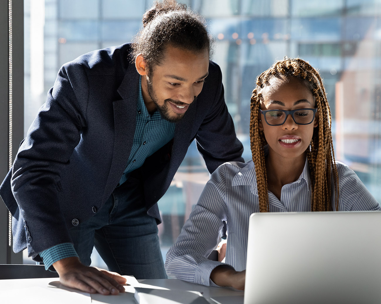 Twee collega's kijken samen op laptop