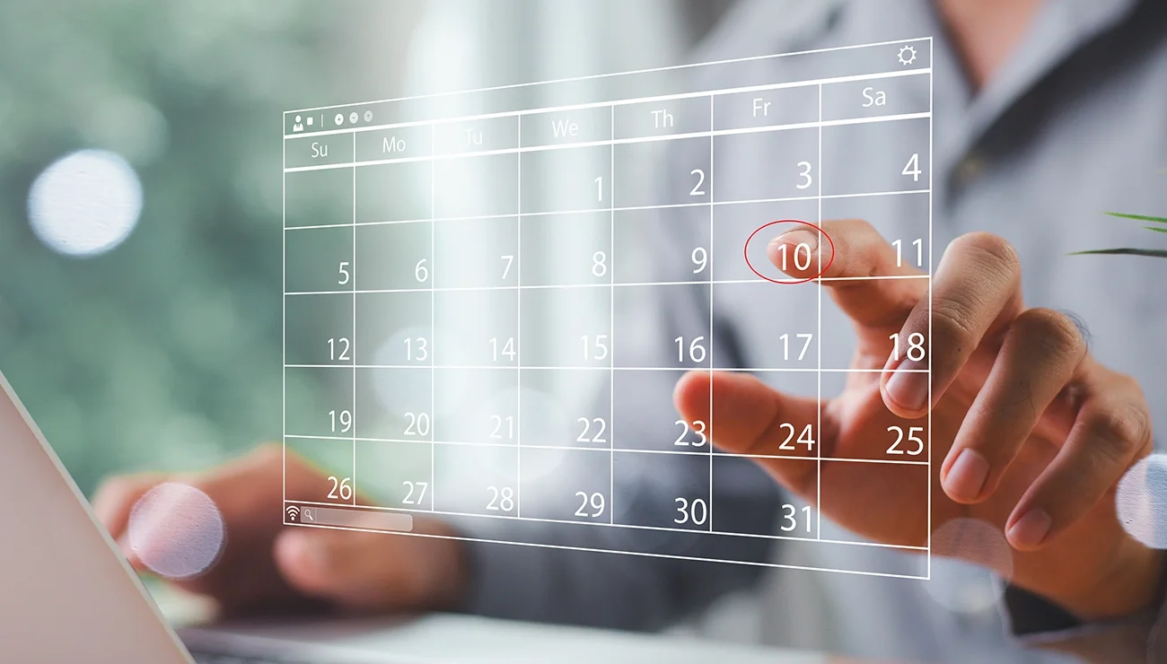 Foto van een persoon die aan het plannen is op een touchscreen met een kalender
