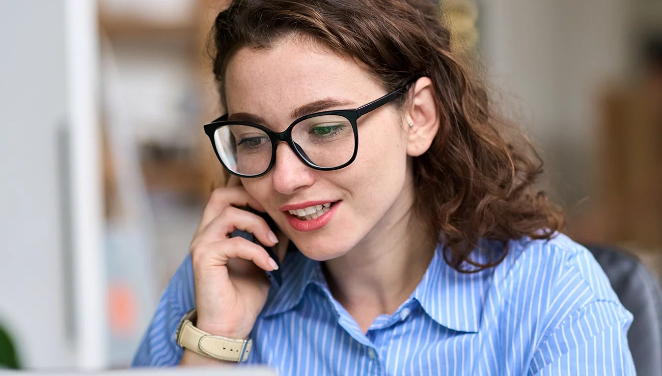 Vrouw houdt een telefoon aan haar oor en is aan het bellen