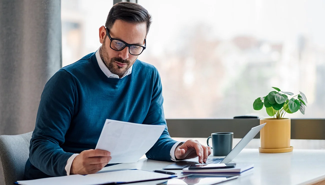 Man bekijkt papieren op zijn bureau