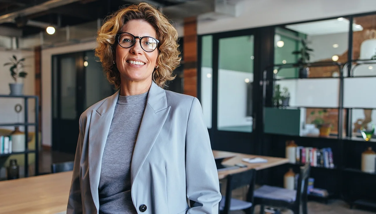 Manager straalt vertrouwen in lichte werkruimte