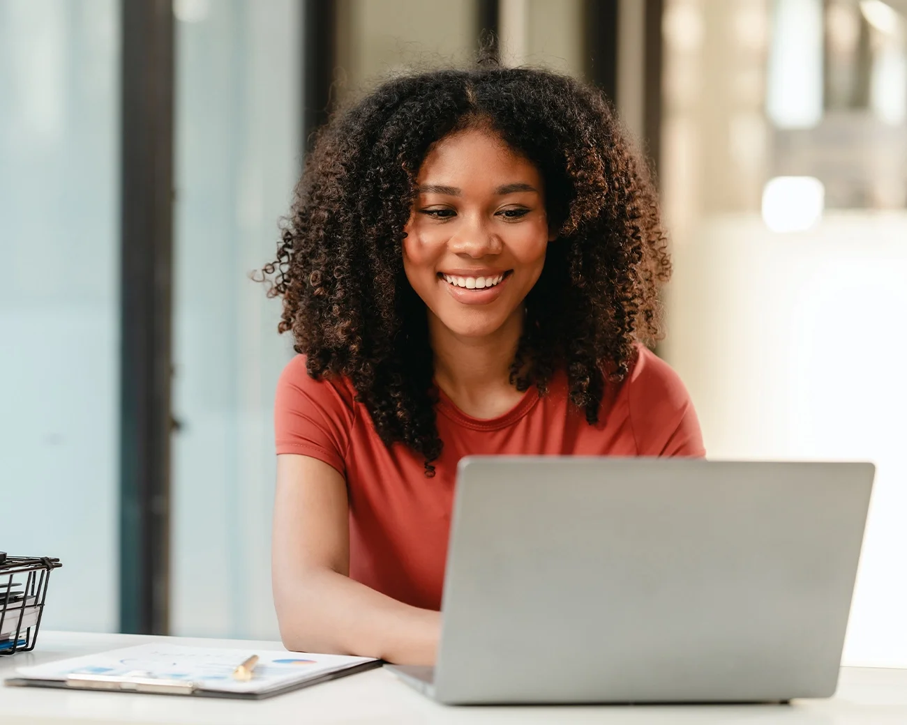 Vrouw kijkt lachend naar laptopscherm