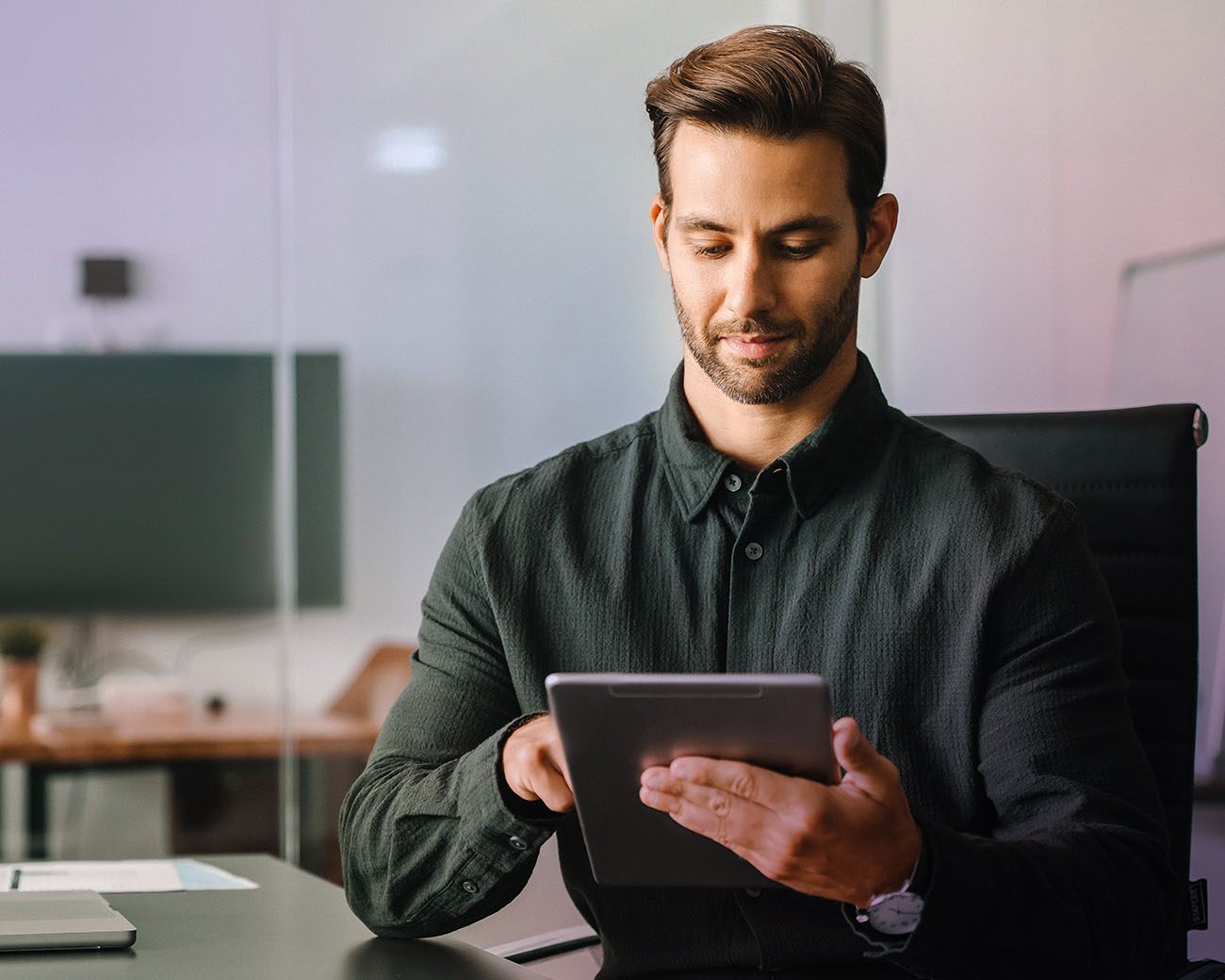 Man werkt op tablet aan bureau