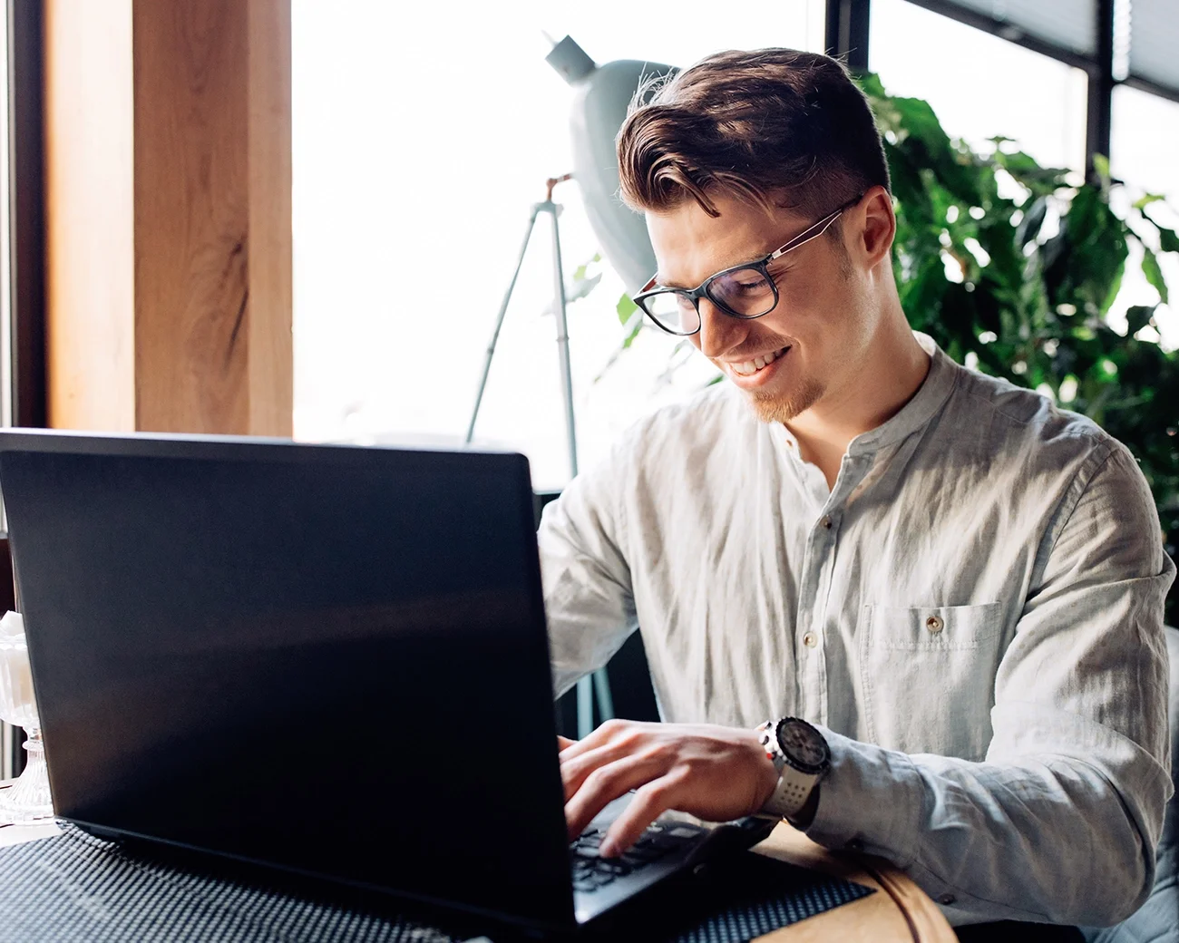 Man lachend achter laptop