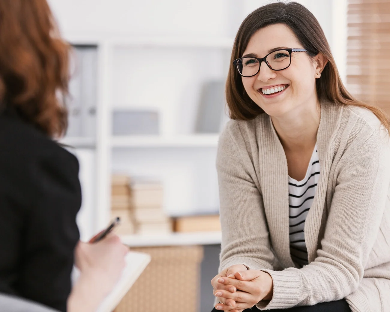Jonge vrouw met bril in gesprek