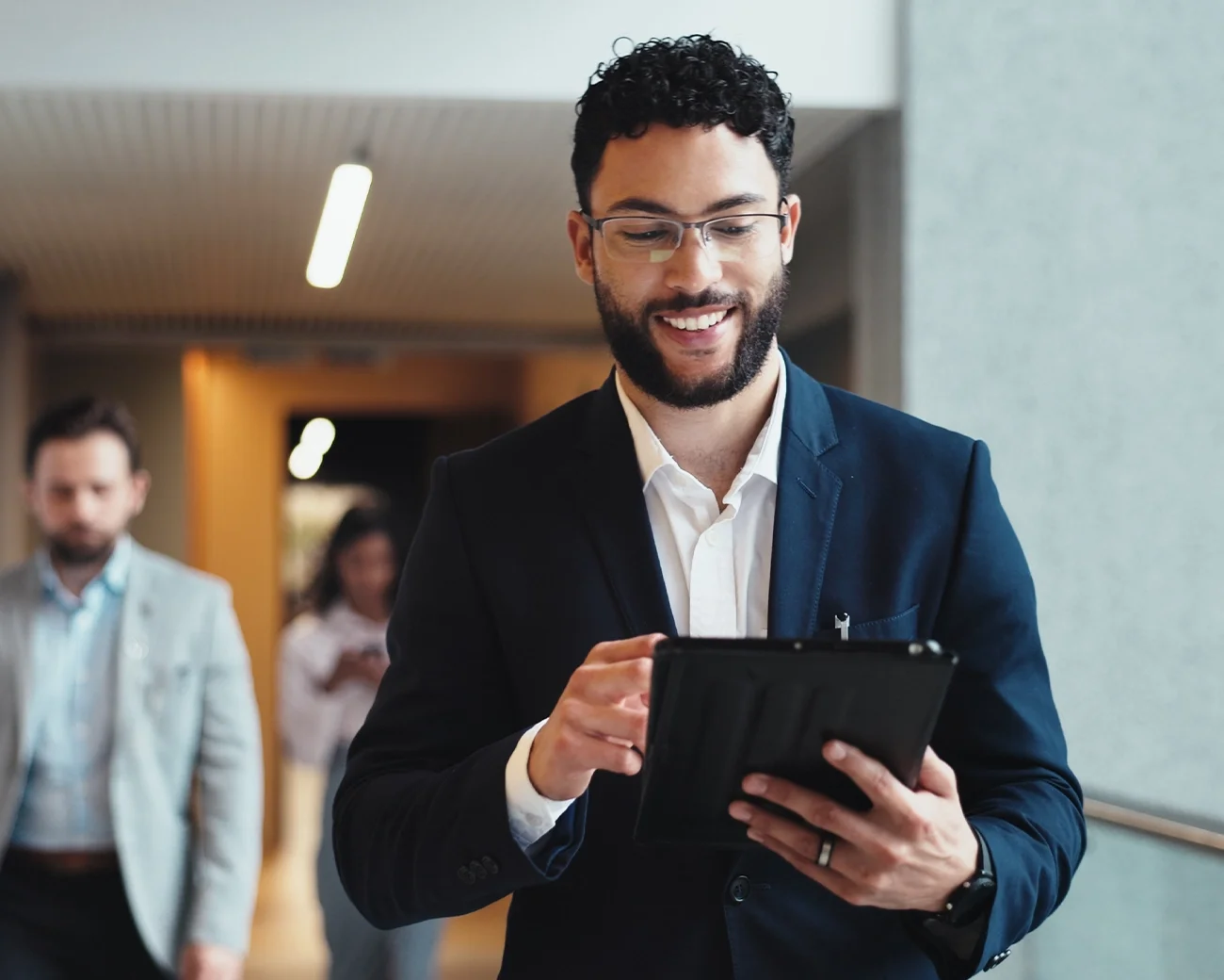 Manager loopt door kantoorgang met IPad