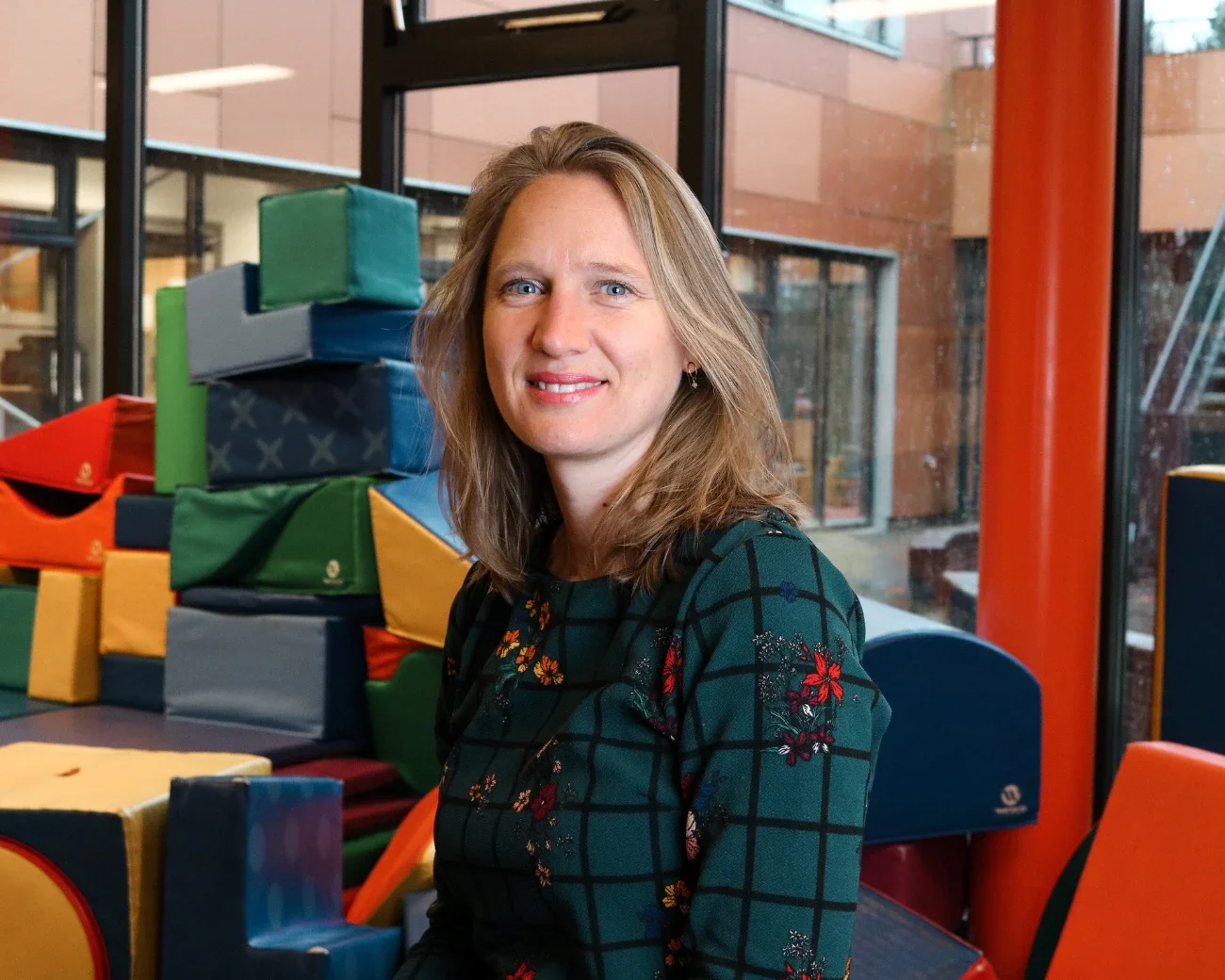 Marieke in een kinderopvang met grote speelblokken op de achtergrond