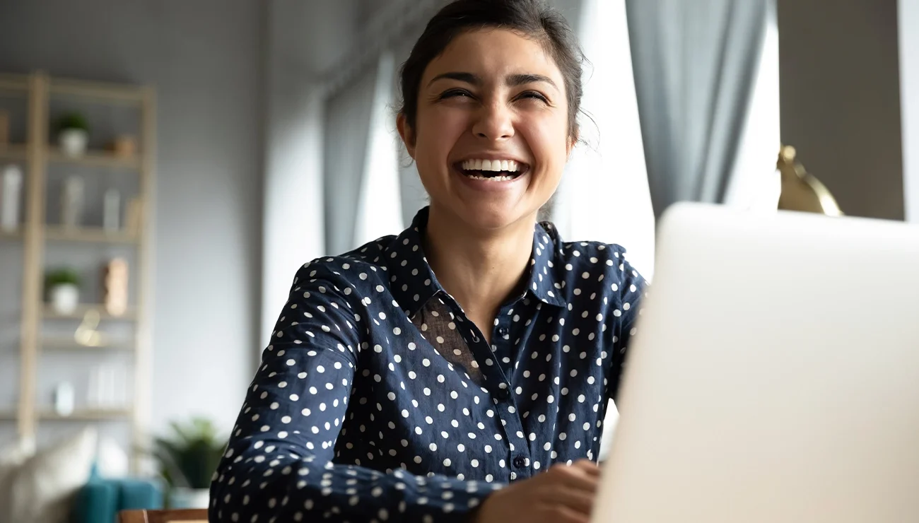 vrolijke vrouw aan het werk achter de laptop