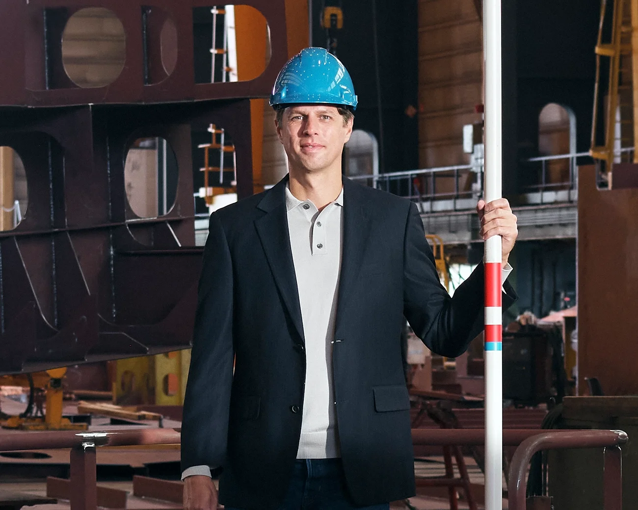 Zakenman met bouwhelm en polsstok