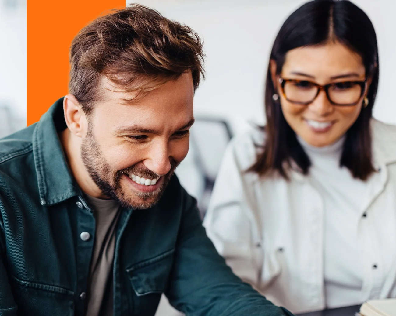 Man en vrouw kijken lachend naar beeldscherm