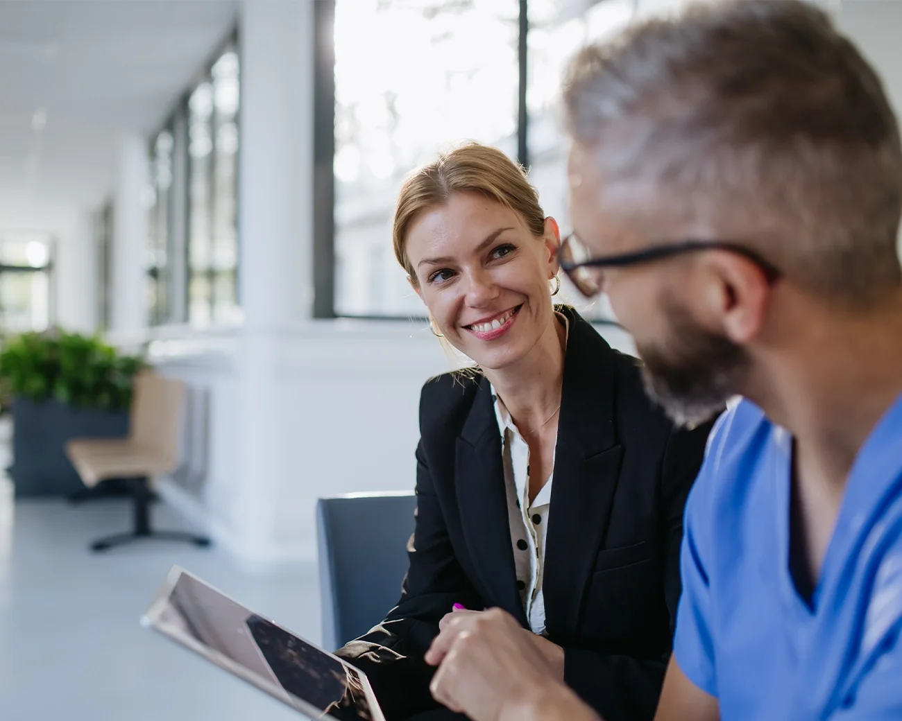 Man en vrouw in zakelijke omgeving en vrolijk in gesprek