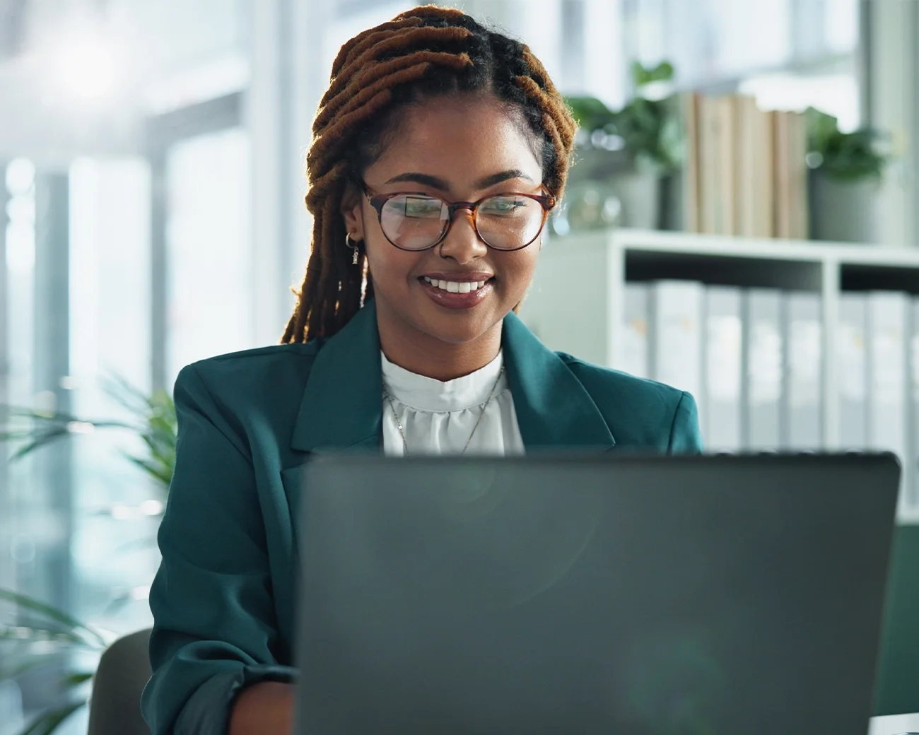 Bestuurskundige zit achter laptop in kantooromgeving