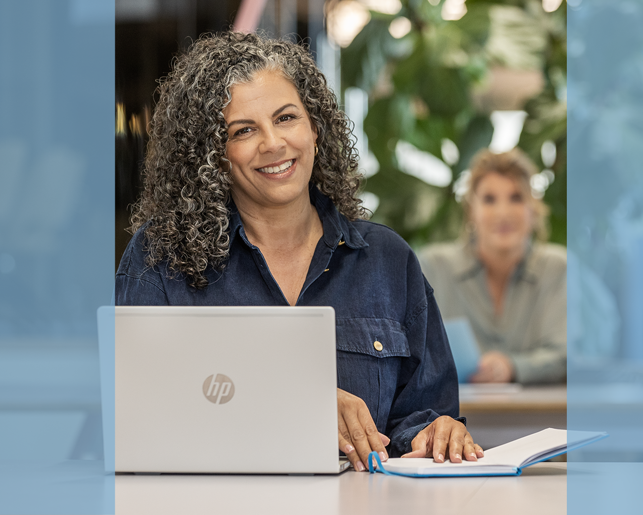 Supportprofessional zit in klaslokaal achter laptop