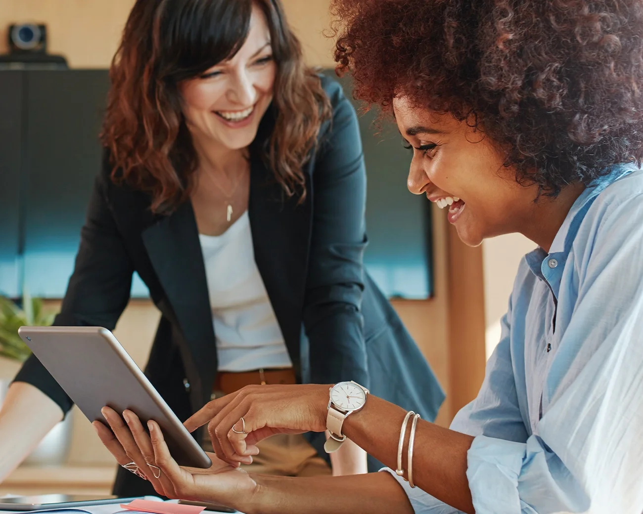 Twee vrouwen lachen samen om tablet