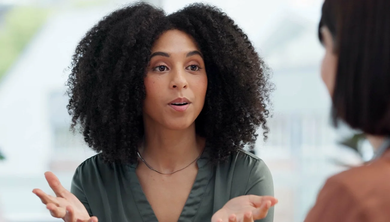 Twee vrouwen zitten tegenover elkaar en voeren een gesprek