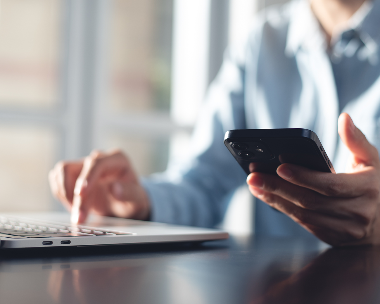 Persoon zoekt contact via laptop en telefoon