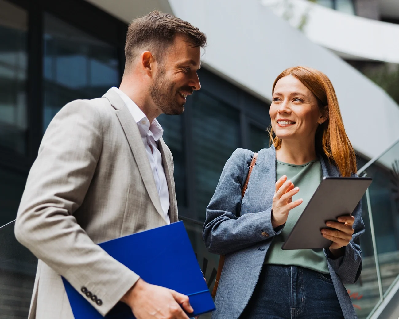 Twee professionals met elkaar in gesprek voor kantoorgebouw