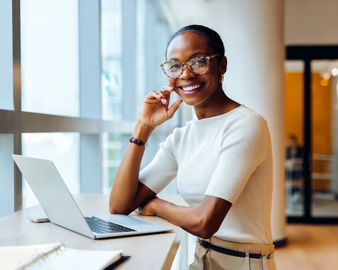 Vrouw steunt op arm achter laptop