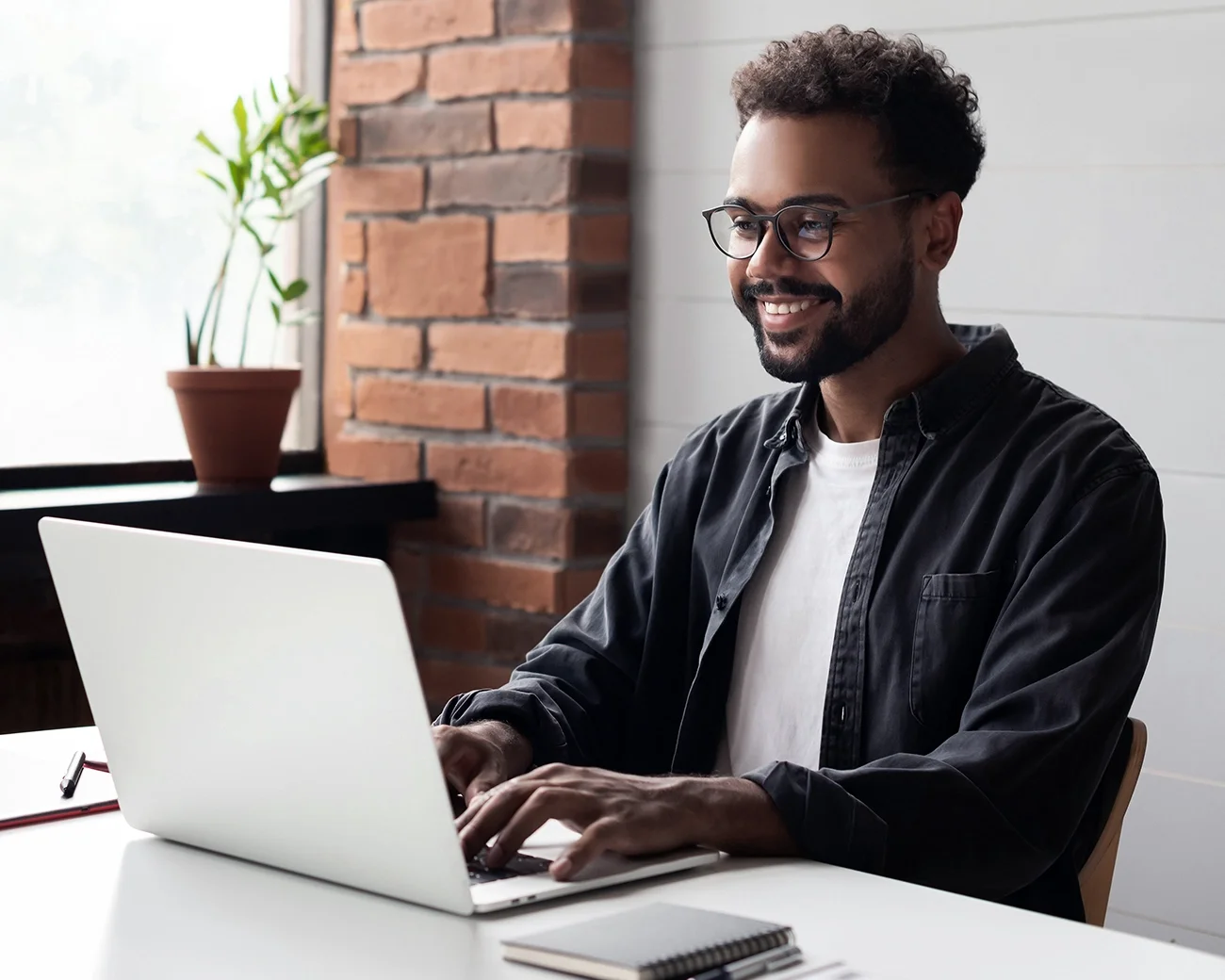 Man lachend achter laptop