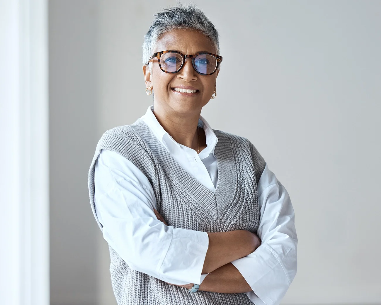 Volwassen vrouw met bril en armen over elkaar