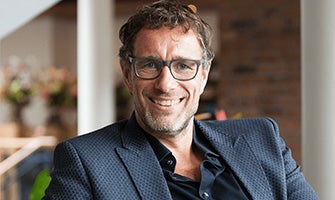 Spreker Arko van Brakel met bril en donkerblauw jasje