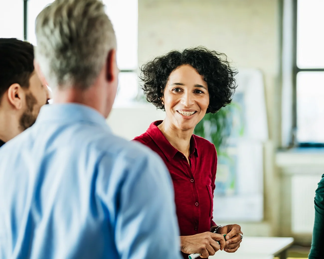 Drie personen praten in een kantoor