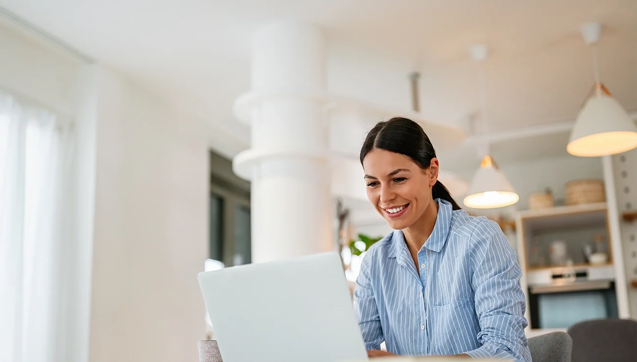 Vrolijke vrouw werkt achter laptop