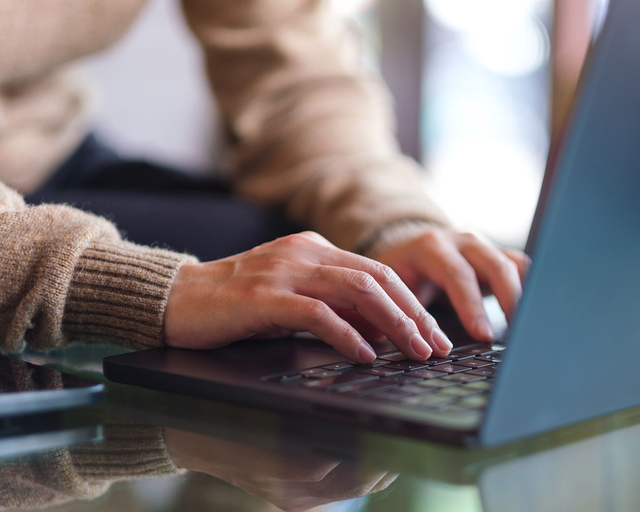 Twee handen typen op laptop